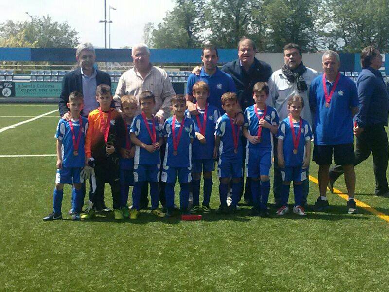 El conjunt de la Fundació Grama posa amb el tinent d'esports de Santa Coloma, Diego Arroyo, el gerent Jaume Abelló i membres de la directiva i tècnics al Nou Municipal